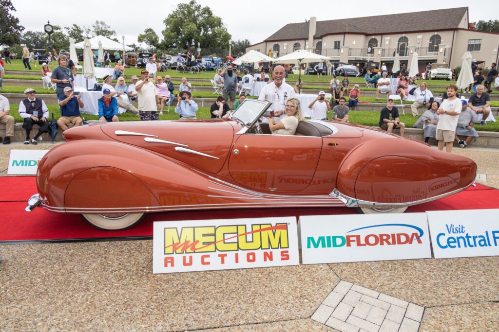 A streamlined copper roadster on the red carpet