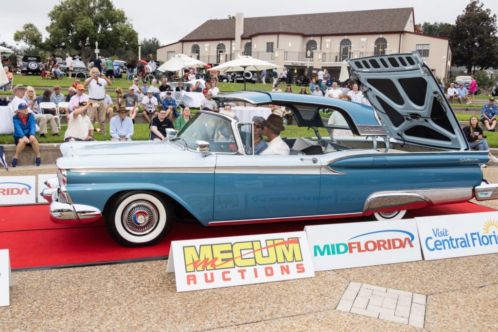 A blue and white convertible with its retractable hardtop raised