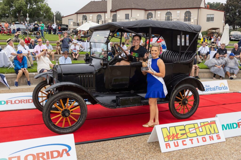 An early black touring car on the red carpet